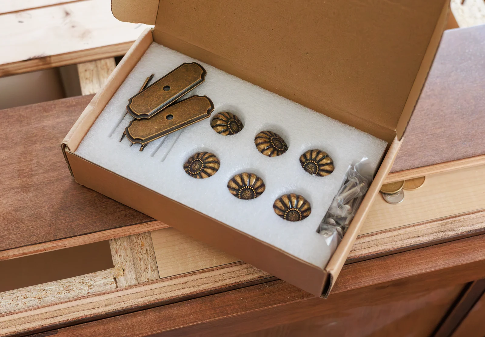 A selection of cabinet knobs and handles in a box